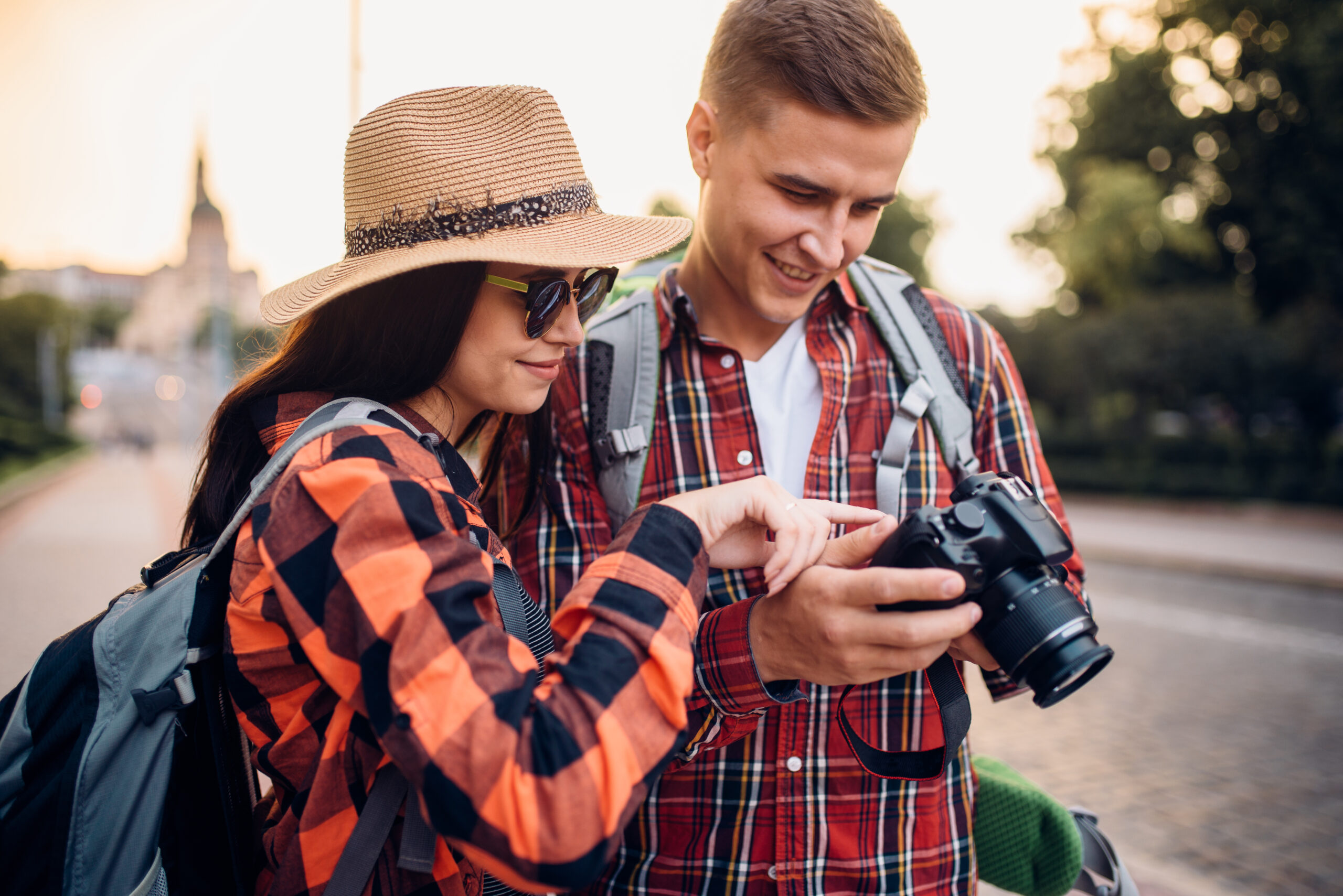 Travelers with backpacks look at the pictures taken. Summer hiking. Hike adventure of young couple